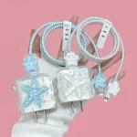 Transparent coils with starfish charms decorative USB charging cables held against a pink background by a gloved hand | PricZone