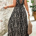 Woman seen from behind in a black and white patterned sleeveless maxi dress with a back tie carrying a woven straw bag by her side | PricZone
