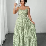 Light Green Tiny Floral Tiered Maxi Dress with Tie Shoulder 3 | PricZone Woman in a green floral maxi dress taking a selfie with a white smartphone in a bright room | PricZone