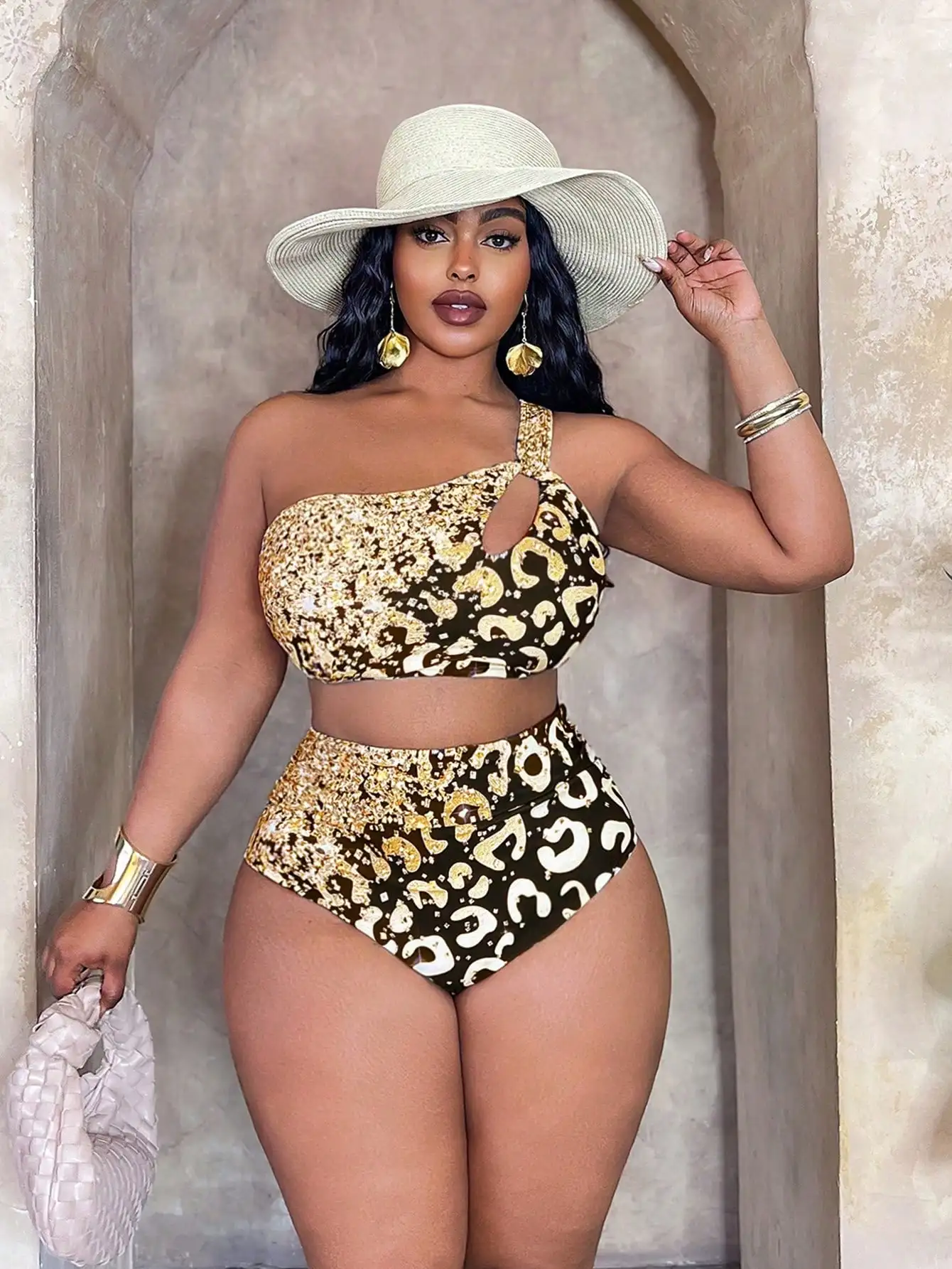 Gold Leopard Print Halter Bikini Set 1 | PricZone Woman in a gold leopard print bikini with a wide brim straw hat posing in a stone doorway with gold jewelry | PricZone