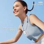 Smiling woman outdoors wearing a white H88 body camera on a magnetic lanyard around her neck | PricZone