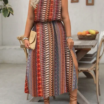 Woman in a sleeveless boho-patterned maxi dress (red, orange, blue) holding a beige woven clutch, wearing brown lace-up sandals.