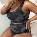 Woman wearing a black ribbed two piece outfit crop top and high waisted shorts with a straw hat bracelets and earrings taking a mirror selfie with a phone | PricZone