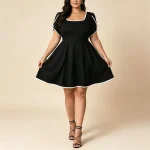 Lace Sleeveless VNeck Cocktail Dress Plus Size 4 | PricZone Woman wearing a black fit and flare dress with white piping posing with hands on the skirt edge | PricZone