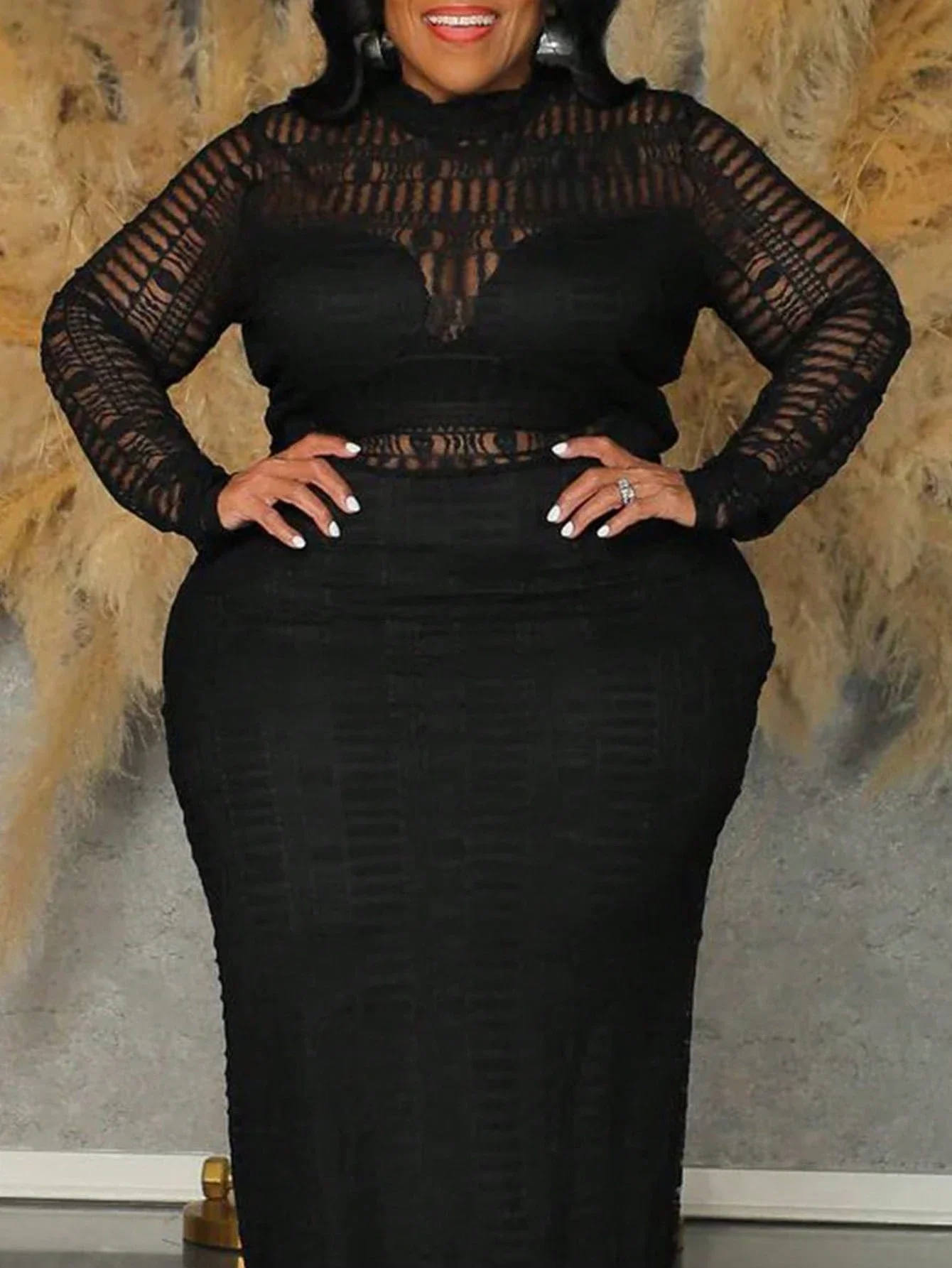 Plus Size Women Semi Sheer Lace Long Slim Fit Summer Dress 3 | PricZone Full length photo of a person in a black lace long sleeve dress standing with hands on hips against a stone wall backdrop | PricZone