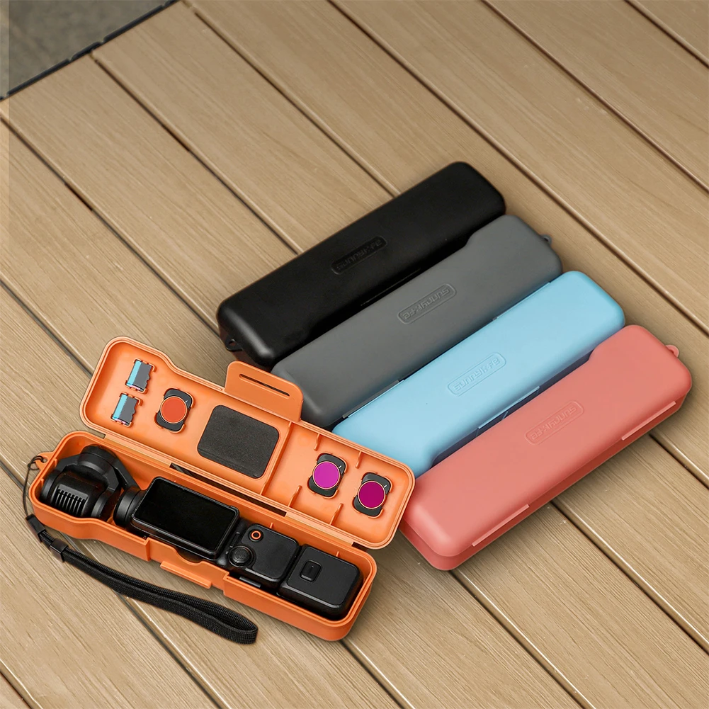 FlipOpen Protective Case for DJI Osmo Pocket 3 with Lanyard 1 | PricZone Open orange硬用具 case reveals an action camera and mounts with additional accessories four closed cases in black gray blue and pink nearby on a wooden surface | PricZone