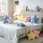 Pastel star shaped cushions on a neatly made bed and light rug in a cozy bedroom | PricZone