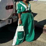 Woman in green and white tracksuit beside a white Mercedes SUV holding a small white handbag | PricZone