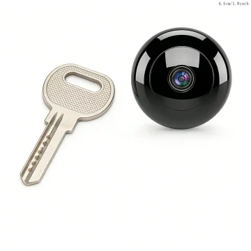 A metal key lying next to a glossy black spherical security camera with a lens in the center on a white background | PricZone