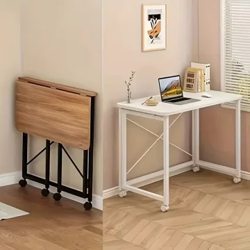 Folded wooden desk with a black frame sits against the wall beside a white rolling desk with a laptop and books | PricZone