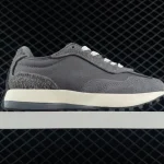 Gray sneaker on a white shelf side view with white laces against a dark grid background showcasing a retro running shoe style | PricZone