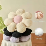Flower Shaped Soft Daisy Decorative Throw Pillow 6 | PricZone A plush knitted flower with cream petals and a pink center stacked on pillows showing soft stuffed fabric and full filling | PricZone