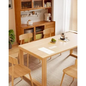 Light wooden dining table with four chairs in a bright kitchen beside a sideboard with a coffee machine and a bowl of pears on the table setting | PricZone