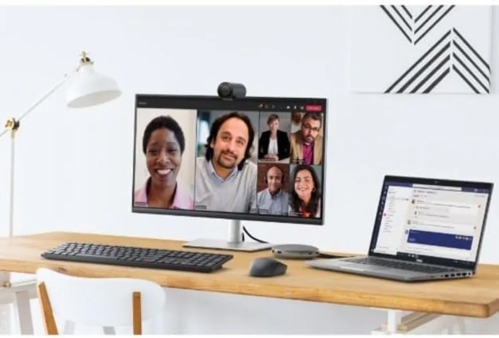 2K Qhd Webcam with Sony Sensor and Noise Reduction Mic 4 | PricZone Desk setup with a monitor displaying a six person video conference a laptop shows a chat app on a wooden desk | PricZone