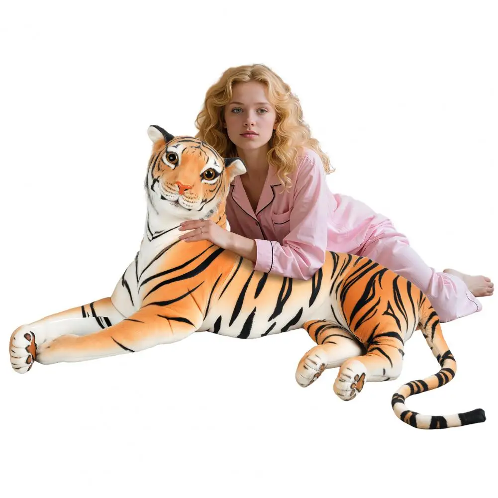 Young woman in pink pajamas lying beside a large tiger plush toy on a white background, gazing at the camera.