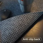 Close up of a dark gray anti slip fabric mat with white dots on a desk with a computer mouse and a metal tumbler nearby | PricZone