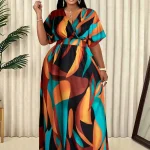 Woman in a bold multicolor abstract print maxi dress posing indoors | PricZone