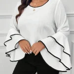 White blouse with wide layered bell sleeves outlined in black trim modeled with gold layered necklaces | PricZone