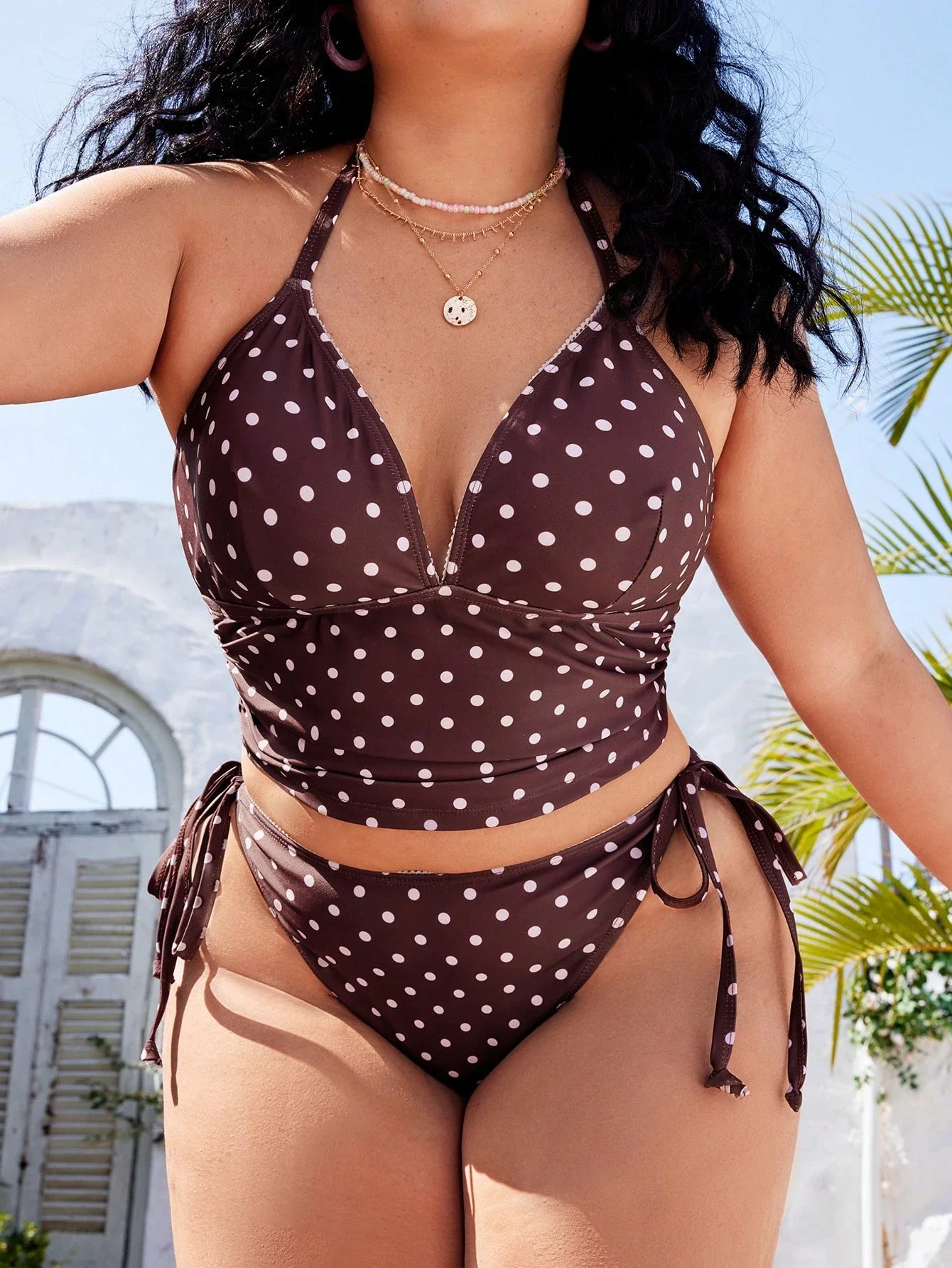 Plus Size Polka Dot Halter Tie Beach Swimwear 3 | PricZone Woman wearing a brown polka dot bikini top with side ties layered necklaces outdoors under sunny sky | PricZone