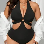 Black Plus Size Halter One Piece Swimsuit with Side Cutouts 6 | PricZone Woman in a black halter swimsuit with a ring cutout at the midsection white shirt draped over shoulders gold necklaces and earrings visible | PricZone