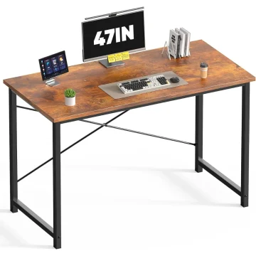 Wooden desk with black metal legs, computer monitor, keyboard, mouse, and accessories (plants, coffee cup, books) arranged on the desk.