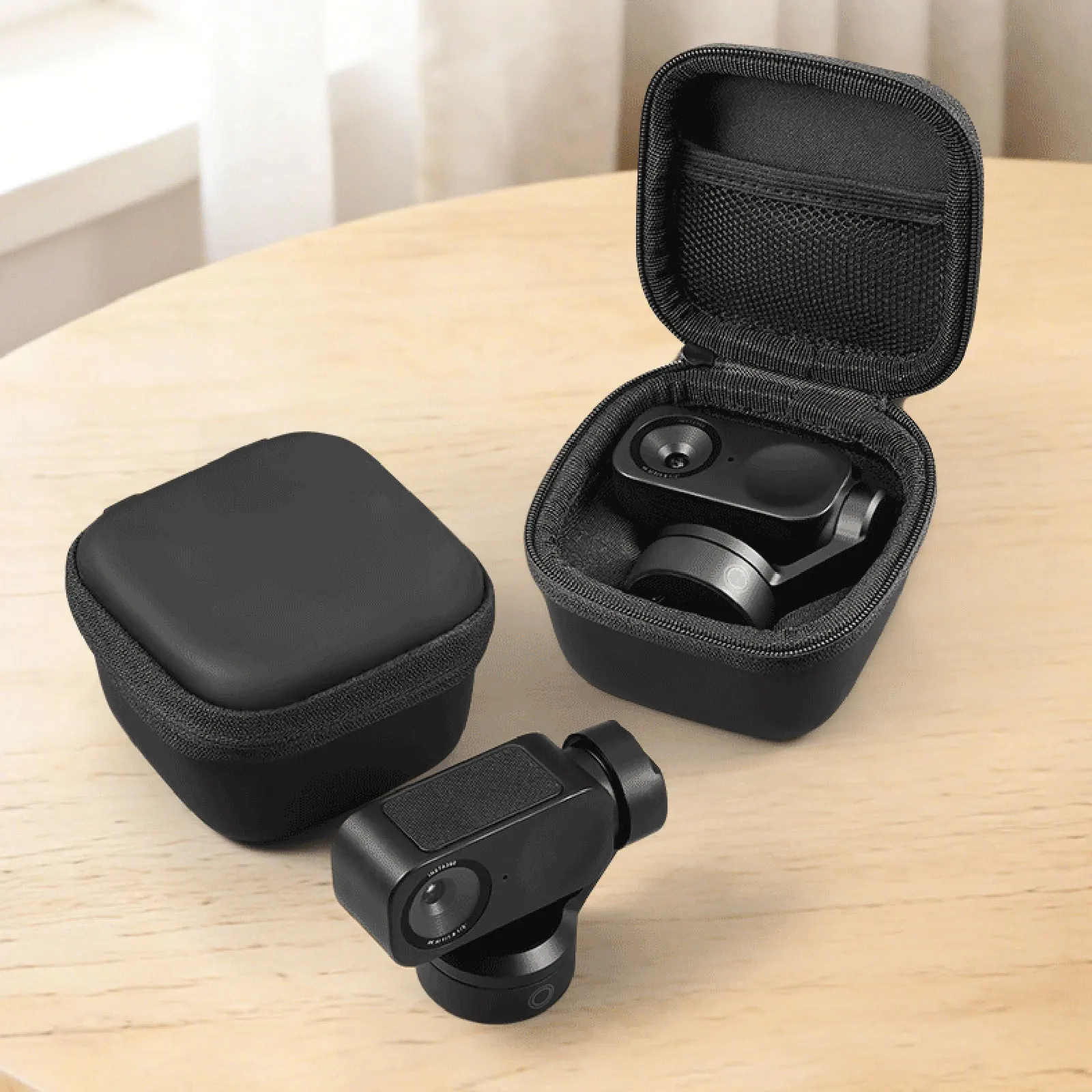 Open black hard case containing a compact handheld camera gimbal on a wooden table; accessories scattered nearby.