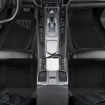 Front center console view gear shift with numerous control buttons and chrome trim flanked by black floor mats on both sides luxury carnTop panel shows controls bottom section highlights rear air vents and center armrest area | PricZone